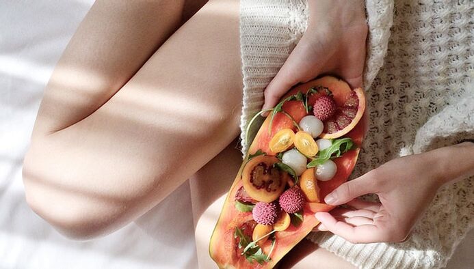 Fille avec papaye et autres fruits